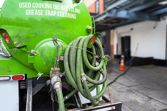 a grease trap being pumped by a sanitation technician in Newnan